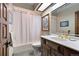 Cozy bathroom featuring a bathtub, white shower curtain, and a classic vanity at 2851 Interlocken Dr, Evergreen, CO 80439