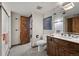 Well-lit bathroom featuring wood cabinets, a decorative mirror, and a separate shower room at 2851 Interlocken Dr, Evergreen, CO 80439