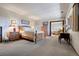 Spacious bedroom with carpeted floor, wood furniture, and decorative lighting at 2851 Interlocken Dr, Evergreen, CO 80439