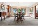 Bright dining area featuring a chandelier, neutral tones, and a large window overlooking the surrounding landscape at 2851 Interlocken Dr, Evergreen, CO 80439