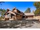 Stunning exterior of a rustic, wood-clad home with a stone foundation and a multi-car attached garage at 2851 Interlocken Dr, Evergreen, CO 80439
