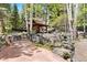 Beautiful lush garden area with a gazebo, pond, rocks, and mature landscaping at 2851 Interlocken Dr, Evergreen, CO 80439