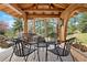 Cozy gazebo with seating area offering beautiful views of the lush backyard and surrounding landscape at 2851 Interlocken Dr, Evergreen, CO 80439