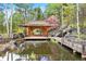 Beautiful backyard oasis with a gazebo on a pond and surrounded by lush landscaping and rock features at 2851 Interlocken Dr, Evergreen, CO 80439