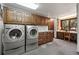 Convenient laundry room featuring a washer, dryer, and ample storage with wooden cabinets for an organized space at 2851 Interlocken Dr, Evergreen, CO 80439