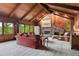 Cozy living room with wood-paneled walls, vaulted ceiling, stone fireplace, and comfortable seating at 2851 Interlocken Dr, Evergreen, CO 80439