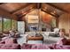 Spacious living room featuring a stone fireplace, wood-paneled walls, and comfortable seating at 2851 Interlocken Dr, Evergreen, CO 80439