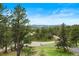 Scenic view of wooded neighborhood with mountain backdrop on a clear day at 2851 Interlocken Dr, Evergreen, CO 80439