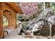 Waterfall cascading next to the gazebo, flowing into pond with lush landscaping at 2851 Interlocken Dr, Evergreen, CO 80439