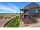 Spacious backyard featuring a covered deck, stone accents, lush lawn, and scenic views at 8086 S Grand Baker Way, Aurora, CO 80016