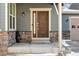 House's front entrance with brown door, stone accents, and a covered porch at 8086 S Grand Baker Way, Aurora, CO 80016