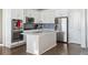 Modern kitchen with white cabinets, quartz island, and stainless steel appliances at 8086 S Grand Baker Way, Aurora, CO 80016