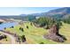 Picturesque aerial view of a golf course community nestled among mountains and a lake at 4502 Echo Cliff Ln, Larkspur, CO 80118