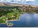 Breathtaking aerial view of a golf course and lake surrounded by trees and mountain views at 4502 Echo Cliff Ln, Larkspur, CO 80118