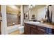 Bathroom featuring a tub shower, vanity with solid surface countertop and ample cabinet space at 4502 Echo Cliff Ln, Larkspur, CO 80118