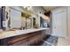 Bathroom featuring double sinks, granite countertop, dark wood cabinetry and glass enclosed shower at 4502 Echo Cliff Ln, Larkspur, CO 80118