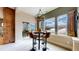 Bright dining area with a modern chandelier, a table with four chairs, and scenic winter views at 4502 Echo Cliff Ln, Larkspur, CO 80118