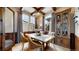 Charming dining room with wood-paneled walls, a glass-top table, and elegant built-in cabinet at 4502 Echo Cliff Ln, Larkspur, CO 80118
