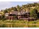 Expansive home with decks overlooking the lake, featuring a rustic, wooded design at 4502 Echo Cliff Ln, Larkspur, CO 80118