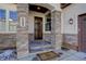 Inviting front entrance with stone pillars, decorative light fixture, and tiled steps at 4502 Echo Cliff Ln, Larkspur, CO 80118