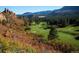 Lush golf course with vibrant autumn foliage and mountain views for an idyllic outdoor experience at 4502 Echo Cliff Ln, Larkspur, CO 80118