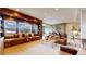 Inviting living room featuring a window seat with scenic views and a comfortable leather sofa at 4502 Echo Cliff Ln, Larkspur, CO 80118
