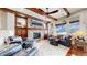 Elegant living room featuring a stone fireplace, wood beams, and comfortable leather seating at 4502 Echo Cliff Ln, Larkspur, CO 80118