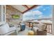 Covered outdoor patio featuring a stone accent wall, mounted TV, and comfortable seating area at 4502 Echo Cliff Ln, Larkspur, CO 80118