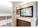 Modern bathroom features a dark wood vanity with mosaic tile accents, a large mirror, and updated lighting at 5250 S Huron Way # 10-207, Littleton, CO 80120
