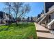 Exterior view showcasing the lawn, pathway, and townhome row with a community pool beyond the fence at 5250 S Huron Way # 10-207, Littleton, CO 80120
