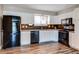 Bright kitchen features stainless steel appliances, white cabinetry, and wood-look flooring at 5250 S Huron Way # 10-207, Littleton, CO 80120