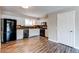 Modern kitchen boasts sleek appliances, ample white cabinets, stylish countertops, and wood flooring at 5250 S Huron Way # 10-207, Littleton, CO 80120