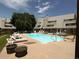 Inviting community swimming pool surrounded by lounge chairs and lush greenery at 5250 S Huron Way # 10-207, Littleton, CO 80120