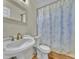 Cozy bathroom featuring a white pedestal sink and a toilet with a floral shower curtain at 778 S Fairplay Ct, Aurora, CO 80012