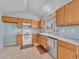 Functional kitchen featuring light wood cabinetry, white appliances, and neutral countertops at 778 S Fairplay Ct, Aurora, CO 80012