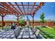 Backyard patio has a pergola, dining table, grill, and a beautiful view of the open landscape at 7433 Ellingwood Cir, Frederick, CO 80504