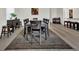 Dining room featuring a dark table with seating for eight, a decorative area rug, and wood-look flooring at 7433 Ellingwood Cir, Frederick, CO 80504