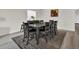 Dining room featuring a dark wood table set, seating for eight, a patterned rug, and wood-look flooring at 7433 Ellingwood Cir, Frederick, CO 80504