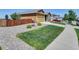 View of home from left side of property showing green lawn and rock landscaping at 7433 Ellingwood Cir, Frederick, CO 80504
