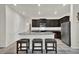 Modern kitchen with dark cabinets, granite counters, stainless steel appliances, and a center island with stool seating at 7433 Ellingwood Cir, Frederick, CO 80504