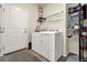 Bright laundry room features a washer and dryer, shelving for storage, and wood-look flooring at 7433 Ellingwood Cir, Frederick, CO 80504