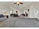 Open concept living room and dining area with plush carpeting, a gray sofa, and wood-look floors leading to kitchen at 7433 Ellingwood Cir, Frederick, CO 80504