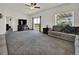 Comfortable living room featuring plush carpeting, a gray sofa, natural lighting, and access to the outdoor living space at 7433 Ellingwood Cir, Frederick, CO 80504