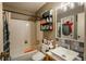 Well-lit bathroom with blue tiled accents, a large mirror, and a tub with shower at 2699 S Xanadu Way # A, Aurora, CO 80014