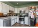 Charming kitchen with white cabinetry, stainless steel appliances, and a garden window at 2699 S Xanadu Way # A, Aurora, CO 80014