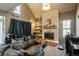 Spacious living room with a stone fireplace, vaulted ceiling, and large windows for plenty of natural light at 2699 S Xanadu Way # A, Aurora, CO 80014