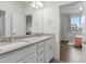 Modern bathroom with a double vanity, a large mirror, and tiled floors at 9378 E 60Th Pl, Denver, CO 80238