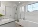 All white bathroom with a glass enclosed shower, soaking tub, and modern fixtures at 9378 E 60Th Pl, Denver, CO 80238