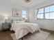 Light-filled bedroom with hardwood floors, plush rug, and two large windows at 9378 E 60Th Pl, Denver, CO 80238