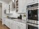 White kitchen boasts stainless steel appliances, a gas range, and contemporary finishes at 9378 E 60Th Pl, Denver, CO 80238